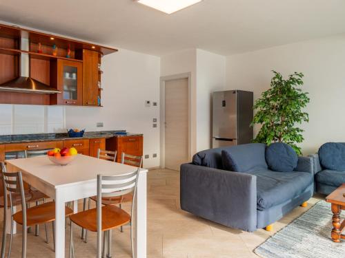 eine Küche und ein Wohnzimmer mit einer Couch und einem Tisch in der Unterkunft Apartment Girasole - GLA128 by Interhome in Gera Lario