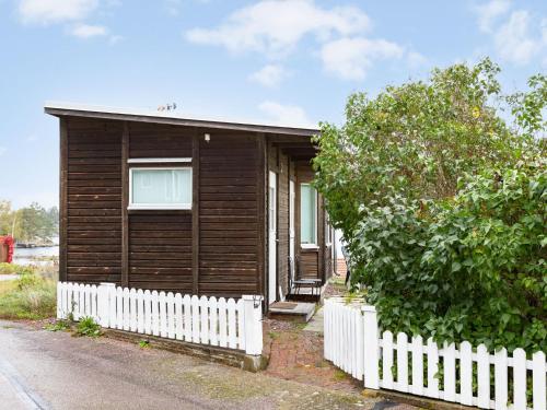 a small wooden house with a white fence at Holiday Home Valbergsudden Utsikten by Interhome in Oskarshamn