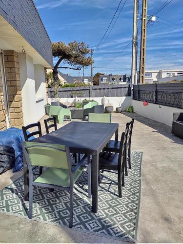 une table et des chaises assises sur une terrasse dans l'établissement Bord de mer, à Ploemeur