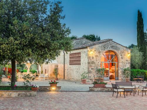 ポッジボンシにあるApartment Rosa Bianca by Interhomeの中庭のテーブルと椅子が備わる石造りの建物