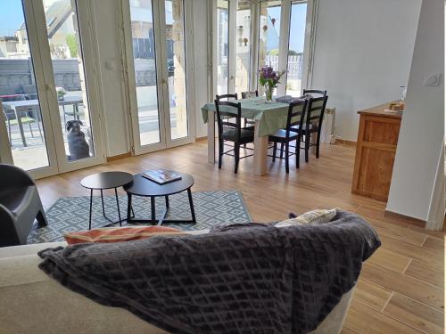 un salon avec un canapé et une table avec des chaises dans l'établissement Bord de mer, à Ploemeur