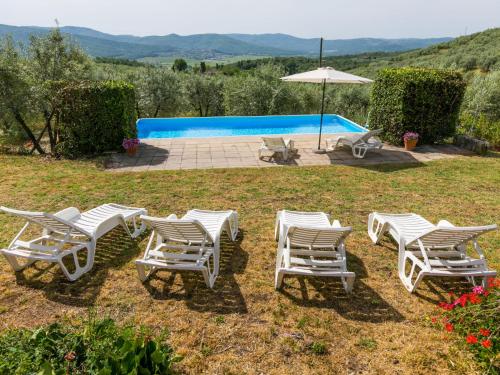 un groupe de chaises et un parasol à côté d'une piscine dans l'établissement Holiday Home Il Forno by Interhome, à Pergine Valdarno