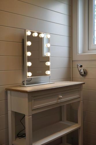 a bathroom vanity with a mirror with lights on it at EASTRIDGE GLAMPING in Shrewsbury