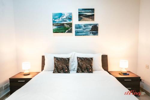 una camera da letto con un letto bianco con due lampade di Elegant Holiday Home Near Valletta a Floriana