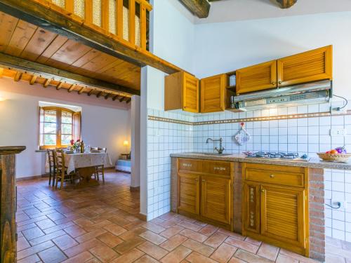 a kitchen with wooden cabinets and a dining room at Apartment Arancione by Interhome in Suvereto