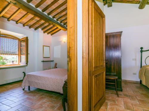 a bedroom with a bed and a wooden door at Apartment Arancione by Interhome in Suvereto