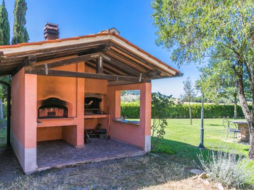 a small outdoor pizza oven in a garden at Apartment Arancione by Interhome in Suvereto