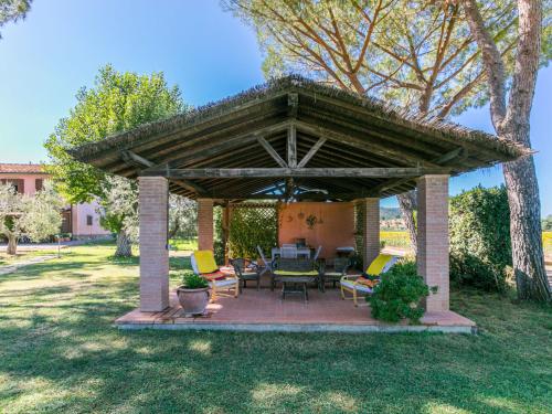a pavilion with chairs and tables in a yard at Apartment Arancione by Interhome in Suvereto