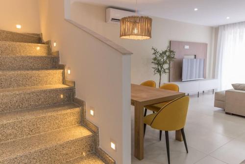 a dining room and living room with a table and stairs at Casa para 8 personas con jardin in Palafolls