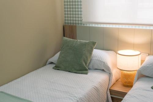 a small bedroom with a bed with a green pillow at Casa para 8 personas con jardin in Palafolls