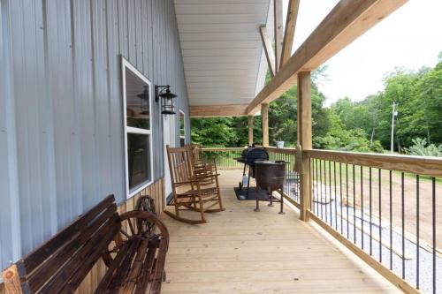 a porch with benches and a grill on a house at Kentucky Coal Cabin 2 min from Lake Cumberland in Jamestown