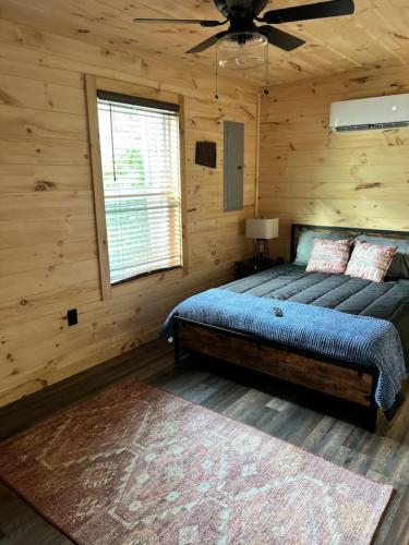 a bedroom with a bed and a ceiling fan at Kentucky Coal Cabin 2 min from Lake Cumberland in Jamestown