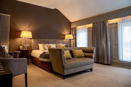 a bedroom with a bed and a couch and a chair at The Enniskillen Hotel and Motel in Enniskillen