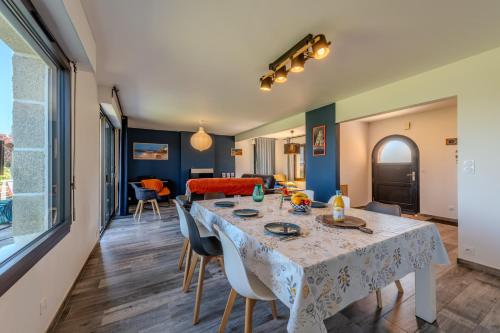 une salle à manger et un salon avec une table et des chaises dans l'établissement Villa - vue mer - 800m de la plage, à Locquirec