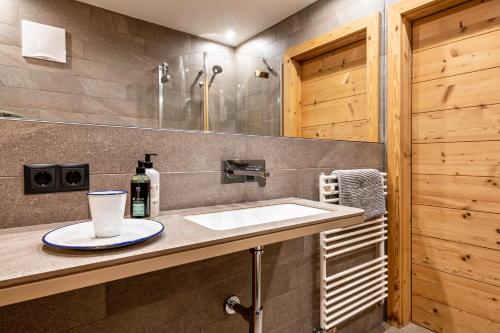 a bathroom with a sink and a shower at Chalet Hubertus in Kastelruth