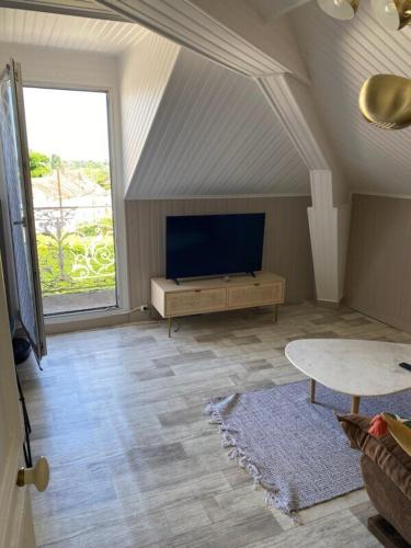 - un salon mansardé avec une télévision et une table dans l'établissement Grand appartement T2 Samois - Rickhoss Home, à Samois-sur-Seine