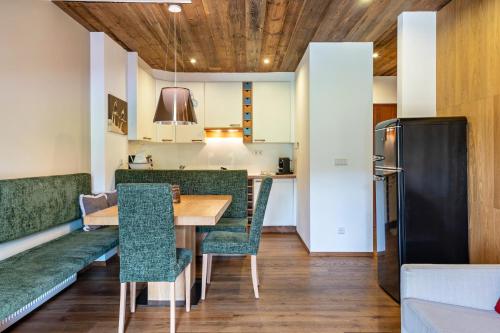 a dining room with a table and green chairs at Chalet Hubertus in Kastelruth