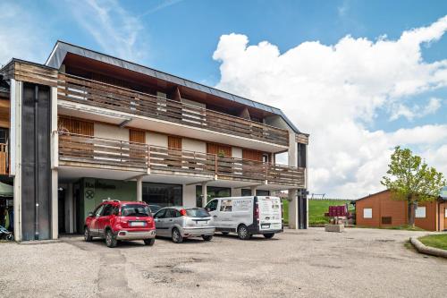 a building with two cars parked in a parking lot at Chalet Hubertus in Kastelruth