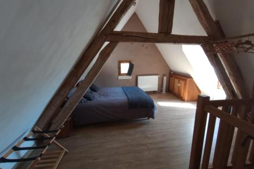a bedroom with a bed in a attic at La Grande Métairie Notz Marafin in Paulnay