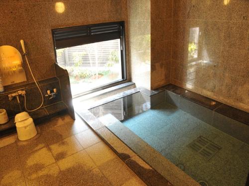 a bathroom with a bath tub and a window at Hotel Route-Inn Utsunomiya Miyukicho -Kokudou4gou- in Utsunomiya