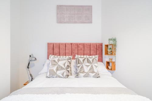 a bedroom with a bed with a red headboard and pillows at Fabulous New 1 Bedroom Ground Floor Flat in Morecambe