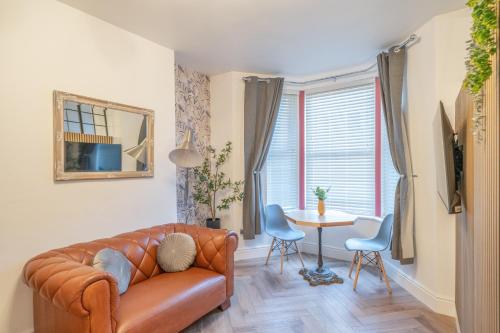 a living room with a leather couch and a table at Fabulous New 1 Bedroom Ground Floor Flat in Morecambe