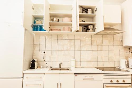 马德里Bravo Murillo Apartment的带白色橱柜和水槽的厨房