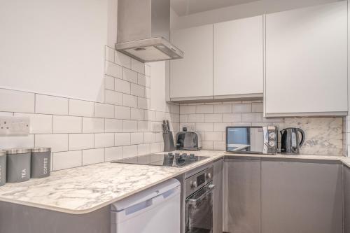 a kitchen with white appliances and white cabinets at Fabulous New 1 Bedroom Ground Floor Flat in Morecambe