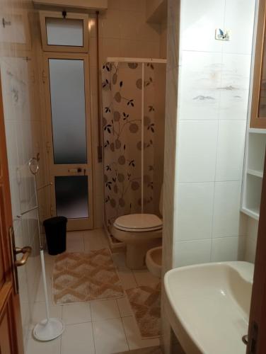 a bathroom with a toilet and a shower and a sink at casa del corso in Canicattini Bagni
