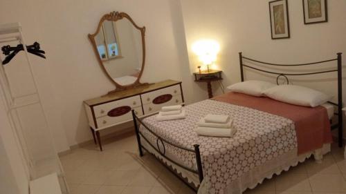 - une chambre avec un lit avec un miroir et une commode dans l'établissement casa del corso, à Canicattini Bagni