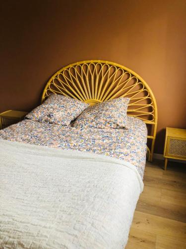 - un lit avec une tête de lit dorée et des oreillers dans l'établissement Appartement sainte Marguerite proche métro et stade vélodrome, à Marseille