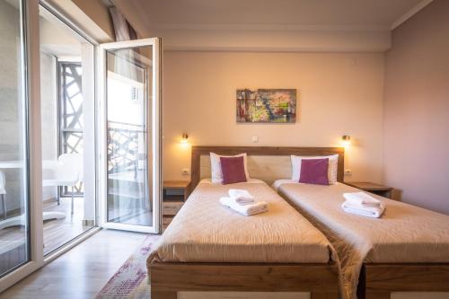 a bedroom with a bed with two towels on it at Boulevard Apartments in Gevgelija