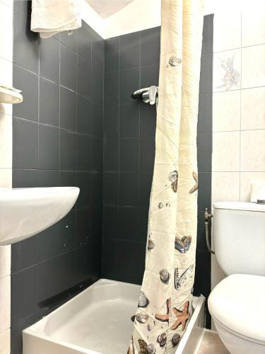 a bathroom with a toilet and a shower curtain at HÖTEL U SANTA MARIA in Olmeto