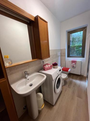 a bathroom with a sink and a washing machine at Casa alla Rocca in Clusone