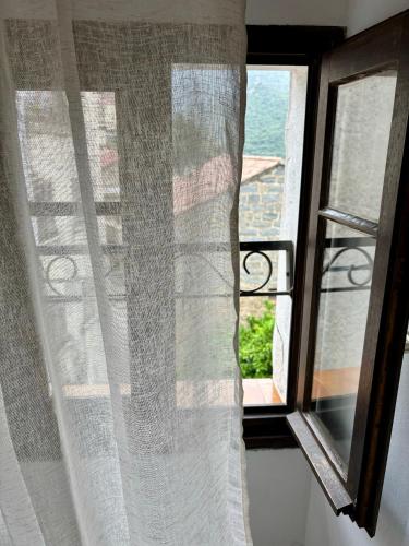 a window with a white curtain and a view at HÖTEL U SANTA MARIA in Olmeto