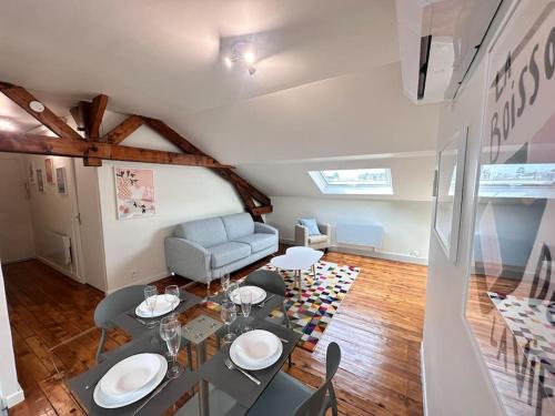 un salon avec une table et un canapé dans l'établissement Forum Champagne grand T2 climatisé vue Cathédrale, à Reims