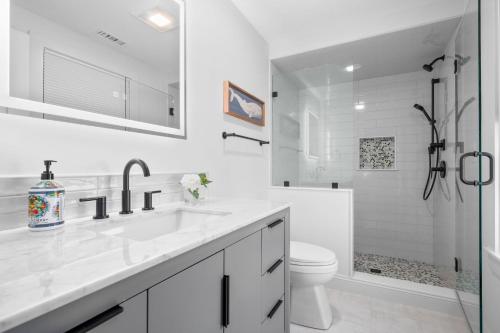 a white bathroom with a sink and a toilet at 37 Clam Shell Drive Chatham - Slow M'Ocean in Chatham