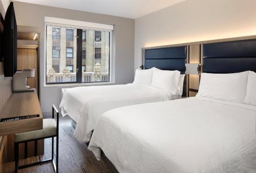 um quarto de hotel com duas camas e uma janela em Holiday Inn Express New York City Chelsea, an IHG Hotel em Nova York