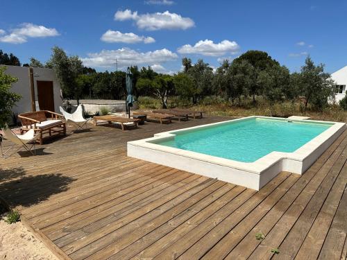a swimming pool on a wooden deck next to a deckership at Amélia's House (Casa das Amélias) in Grândola