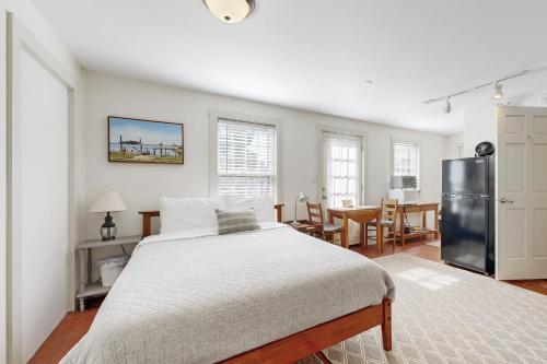 a white bedroom with a bed and a kitchen at Sheepscot Beauty in Wiscasset