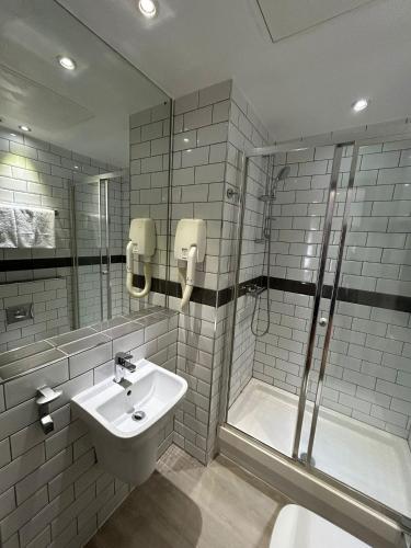 a bathroom with a sink and a shower at London Walthamstow Hotel in London