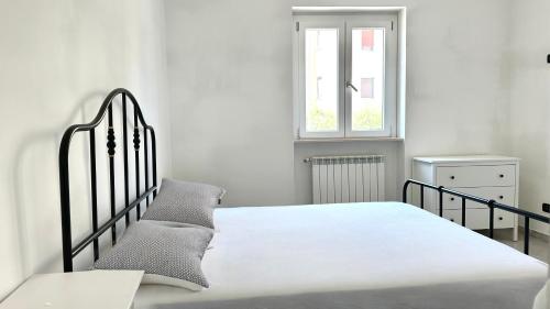 a white bedroom with a bed and a window at SE104 - Elegante quadrilocale comodo ai servizi in Senigallia