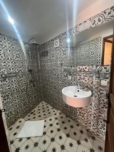 a bathroom with a sink and black and white tiles at Riad Jnan El Cadi in Marrakech