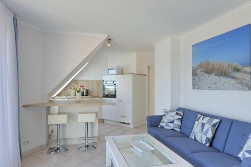 a living room with a blue couch and a table at Strandhaus Brunhild in Timmendorfer Strand