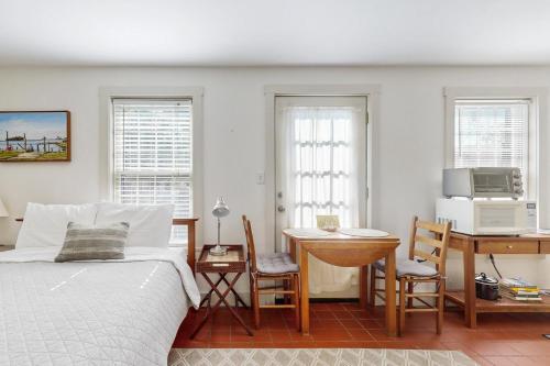 a bedroom with a bed and a table and a desk at Sheepscot Beauty in Wiscasset