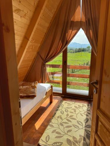 a bedroom with a bed and a window with a view at Durmitorski merak in Žabljak