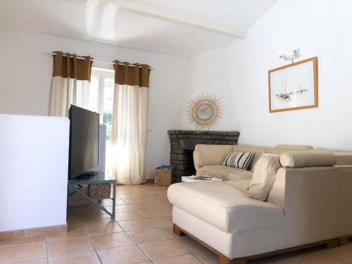 un salon avec un canapé blanc et une télévision dans l'établissement La Ventourinado Villa 12 personnes Piscine chauffée, à Sainte-Maxime