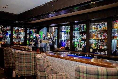 a bar with some chairs and bottles of alcohol at The Enniskillen Hotel and Motel in Enniskillen
