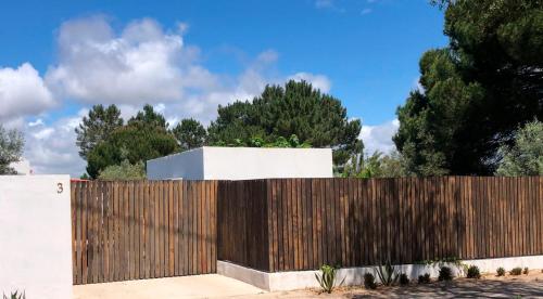 a wooden fence in front of a white building at Amélia's House (Casa das Amélias) in Grândola