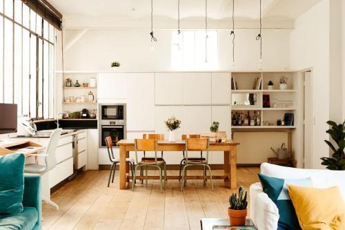 une cuisine et un salon avec une table et des chaises dans l'établissement Sublime loft avec verrières sur le Canal St Martin, à Paris